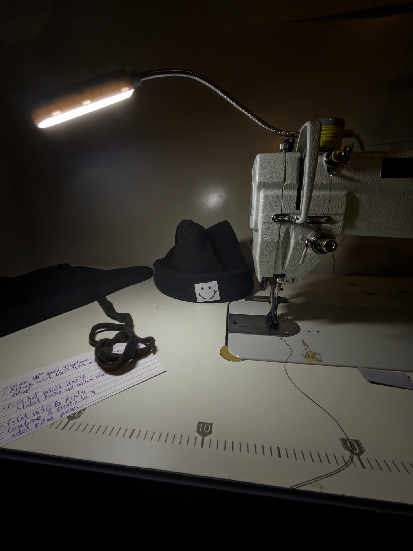 Sewing machine with a hat on a dark background